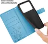 A hand is holding a black silicone phone case over an open blue wallet-style phone case with card slots and a butterfly design. Produktbild-Vorschau