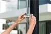 Hands adjusting a shower head on a shower stand. Produktbild-Vorschau