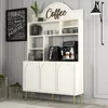 A cream-colored cabinet with arched doors and gold legs, featuring a coffee maker and air fryer on top, set against a light gray wall. Produktbild-Vorschau
