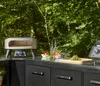 An outdoor kitchen setup with a pizza oven and ingredients. Produktbild-Vorschau