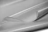 A close-up shot of a gray PVC tarpaulin material, rolled and curved, showcasing its texture and sheen. Voir les images du produit