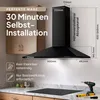 A black kitchen hood is shown installed above a stovetop, with kitchen cabinets in the background. Dimensions and installation information are overlaid on the image. Produktbild-Vorschau