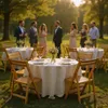 An outdoor wedding reception with tables set for guests and people in the background. Produktbild-Vorschau