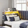 A close-up view of a bed with a headboard featuring integrated LED lighting and storage shelves. Náhled obrázku produktu