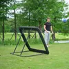A man is playing soccer with a rebounder net in a park. Voir les images du produit
