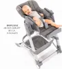 A baby is lying in a high chair that is reclined to a lie-flat position, suggesting it can be used as a baby lounger. Produktbild-Vorschau