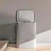 A light gray laundry basket with its lid open, placed against a gray wall. Produktbild-Vorschau