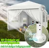 A white party tent set up in a grassy field with sunlight streaming in. Inside, there are two people, a pot with fire, and some bags. Close-up views highlight the tent's anchoring system and a cord attachment. Produktbild-Vorschau