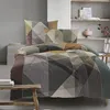 A bed with geometric patterned bedding in a modern bedroom setting. Produktbild-Vorschau