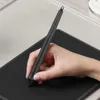 A hand is holding a stylus and drawing on a black graphics tablet. Podgląd zdjęcia produktu