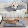 Two dogs are shown resting on pet mats, one on a couch and the other on the floor. Produktbild-Vorschau