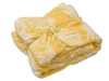 A folded yellow blanket with a white pattern, tied with a yellow ribbon. Náhľad obrázku produktu