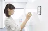 A woman is writing on a whiteboard while a smartphone is attached to the whiteboard. Produktbild-Vorschau