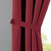 A close-up of a red curtain held back by a tie-back. Produktbild-Vorschau