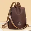 Brauner Nylonrucksack mit braunen Kunstlederträgern und einem silbernen ineinandergreifendem Logo auf der Vorderseite Anteprima dell’immagine prodotto