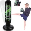 A young boy is kicking an inflatable punching bag with a dinosaur design. Boxing gloves are also visible. Produktbild-Vorschau
