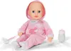 A baby doll wearing a pink pajama set with a hood, sitting on a white surface. A pacifier on a string is attached to the doll's pajama, and a baby bottle is placed next to it. Náhled obrázku produktu