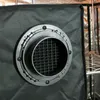 Close-up of a ventilation port with a baffle on a dark fabric surface. Produktbild-Vorschau
