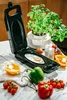 An open multi-grill with a fried egg inside, surrounded by fresh vegetables and a potted plant. Náhľad obrázku produktu