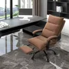 An office chair with a footrest is shown in a modern office setting with a desk and shelves in the background. Produktbild-Vorschau