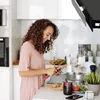 A woman is preparing food in a modern kitchen. Produktbild-Vorschau