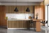 A modern kitchen with wood slat cabinetry, a marble backsplash, and a breakfast bar. Podgląd zdjęcia produktu