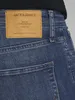 A close-up view of the back pocket and leather patch of blue denim jeans. Produktbild-Vorschau