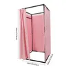 A pink freestanding changing room with a black metal frame, shown from the side with one curtain open. Voir les images du produit