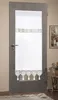 A white lace curtain with a decorative border and tassels is attached to a glass-paneled door. Produktbild-Vorschau