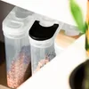 Close-up of three clear plastic food storage containers with white lids, one with a black lid insert, filled with granular food items. Produktbild-Vorschau