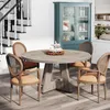 A dining set with a round table and chairs in a room with a staircase and a cabinet. Anteprima dell’immagine prodotto