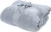A light blue blanket is rolled up and tied with a ribbon and bow. Produktbild-Vorschau