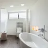 A modern bathroom with a freestanding bathtub, a towel rack, and a basket. Anteprima dell’immagine prodotto