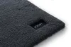 A close-up view of a dark gray bath mat with a black label featuring the 'JOOP!' logo. Podgląd zdjęcia produktu