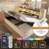 A bed with its storage compartment open, showing a charging station and LED lighting features. Produktbild-Vorschau