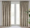 A pair of beige curtains hangs in front of a window. Podgląd zdjęcia produktu