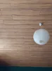 A white paper lantern hangs from the ceiling against a wood-paneled wall. Podgląd zdjęcia produktu