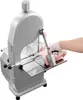 A person wearing a white glove is using a commercial electric meat band saw to cut a piece of meat. Náhled obrázku produktu