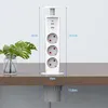 A white retractable power strip with USB ports is shown installed on a wooden desk, with a plant in a glass vase on the desk. Produktbild-Vorschau