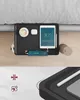 A bedside tray attached to a bed, holding various items including a tablet, phone, earbuds, and a cup of coffee. Produktbild-Vorschau