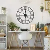 A vintage-style metal wall clock is displayed above a desk in a home office setting. Produktbild-Vorschau