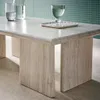 A close-up of a travertine-look coffee table with two glasses of water on it, set against a green tiled background. Produktbild-Vorschau