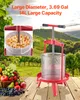 A fruit press and basket of fruit are displayed on a wooden surface with a vineyard in the background. Voir les images du produit
