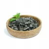 A wooden bowl filled with black shungite stones and a sprig of mint on a white background. Anteprima dell’immagine prodotto