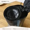 Close-up of a coffee maker's filter basket with a reusable filter inside, set on a wooden surface. Podgląd zdjęcia produktu