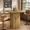 A bar table with two bottles of whiskey and two glasses, set in a room with wooden paneling and a window. Produktbild-Vorschau