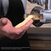 A close-up shot of a hand holding a piece of dough being extruded through a kitchen appliance attachment. Produktbild-Vorschau