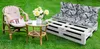 Outdoor seating area with a cat on a chair, a small table with flowers, and a pallet sofa. Produktbild-Vorschau