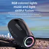 A black portable speaker with colorful lights is displayed on a rocky surface with a blurred background of water and sky. Náhled obrázku produktu