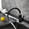 A black kitchen faucet with a flexible hose is shown in a sink, with a lemon on a drying rack. Náhľad obrázku produktu